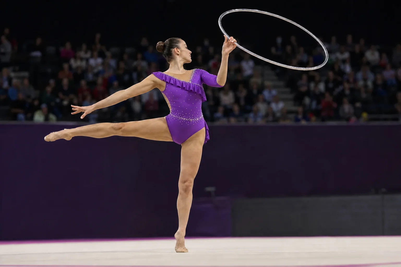 Projection d’une gymnaste rythmique adulte en justaucorps violet réalisant un équilibre avec un cerceau