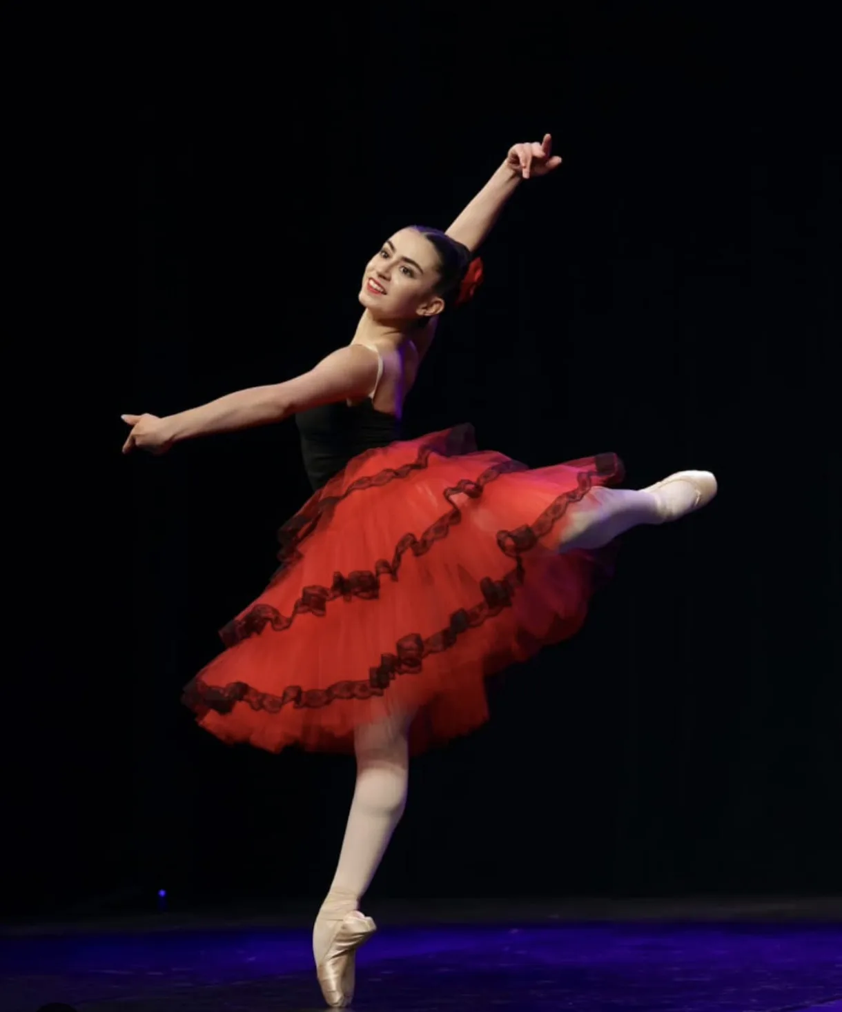 Danseuse portant sur scène un tutu rouge et noir créé par Leprince Studio