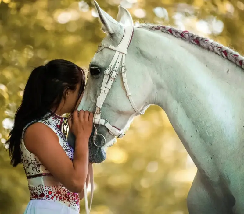Voltigeuse portant son justaucorps sur mesure auprès de son cheval